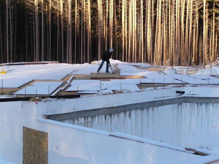 ICF crew setting walls in the snow on a wooded lot
